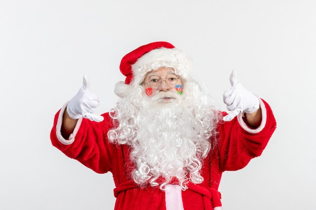 Vista frontale di babbo natale con vernice bandiera azerbaigiana sul suo volto sul muro bianco