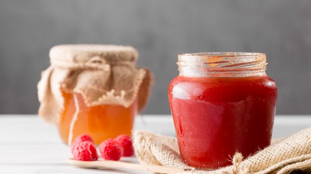 Vista frontale di barattoli di vetro con marmellata di lamponi