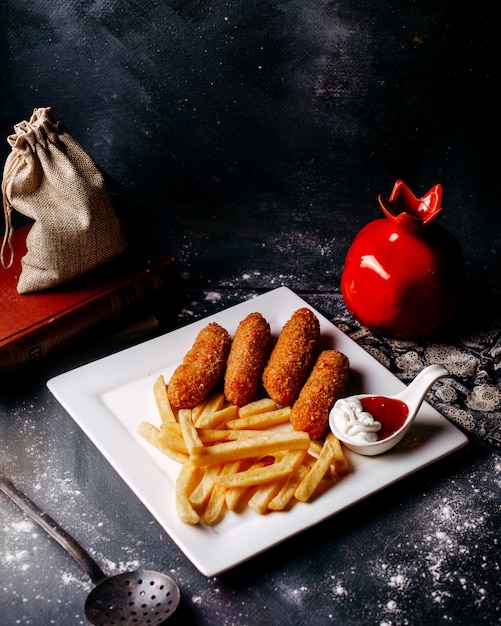 Vista frontale di carne fritta con patatine fritte sulla superficie grigia