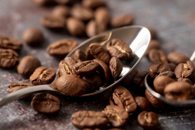 Vista frontale di chicchi di caffè con cucchiai