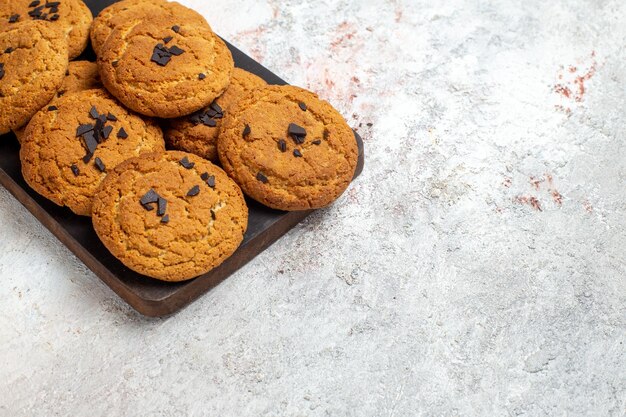 Vista frontale di deliziosi biscotti di sabbia dolci perfetti per una tazza di tè sulla superficie bianca