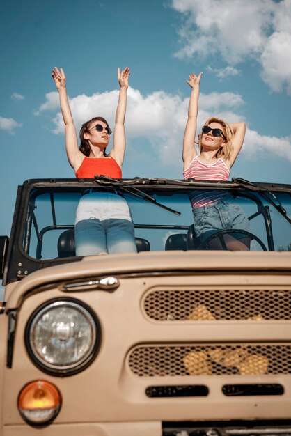 Vista frontale di due donne che si divertono durante il viaggio in auto