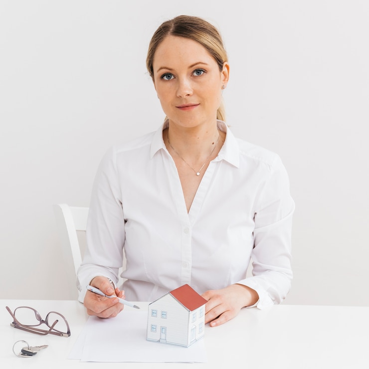 Foto gratuito vista frontale di giovane agente immobiliare professionale che colloca nell&#39;ufficio che guarda l&#39;obbiettivo