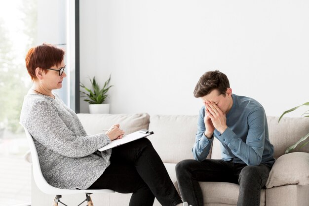 Vista frontale di psicologo e paziente