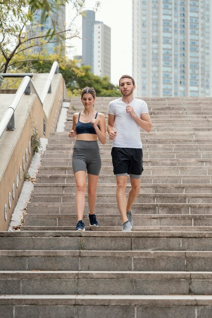 Vista frontale di un uomo e di una donna che esercitano sui gradini