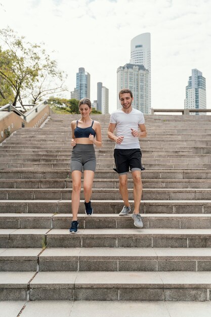 Vista frontale di un uomo e di una donna che esercitano sulle scale