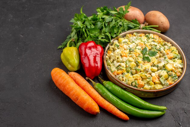 Vista frontale di una deliziosa insalata con verdure fresche sulla superficie scura