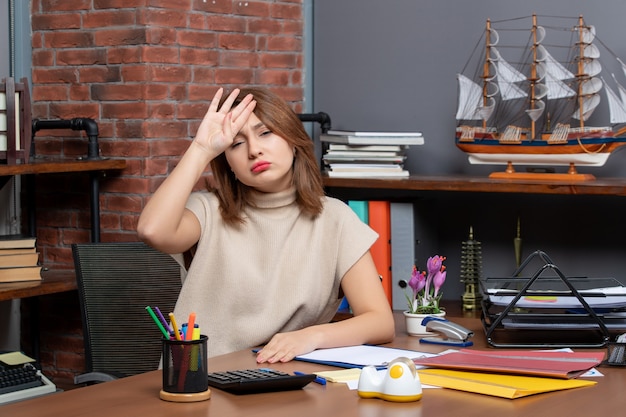 Vista frontale di una donna d'affari stanca seduta alla scrivania in ufficio