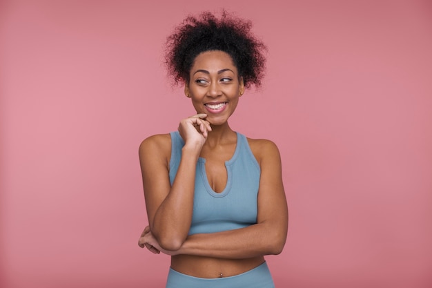 Vista frontale di una giovane donna che pensa a qualcosa che la faccia sorridere