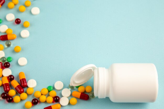 vista frontale diverse pillole con pallone di plastica su sfondo blu laboratorio salute covid ospedale scienza colore virus della droga pandemia