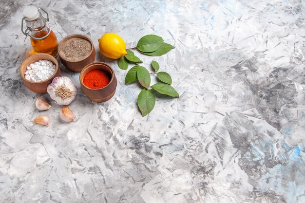 Vista frontale diversi condimenti con limone su olio da tavola bianco pepe piccante di frutta