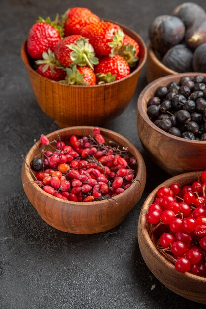 Vista frontale diversi frutti freschi all'interno di piatti su scrivania scura foto a colori di frutta molti succhi morbidi