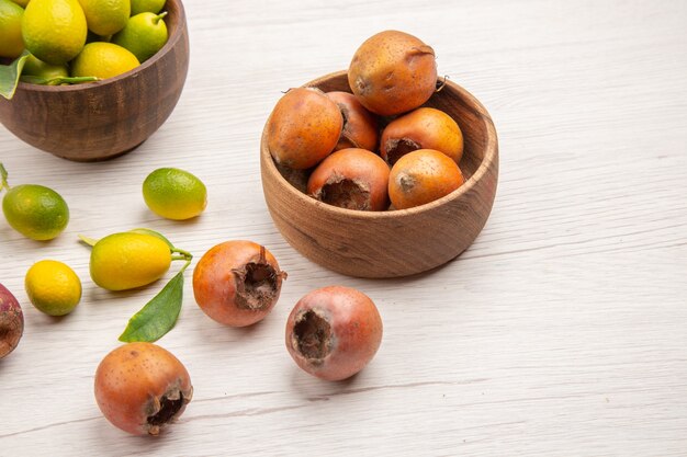 Vista frontale diversi frutti freschi all'interno di piatti su sfondo bianco frutta tropicale maturo colore esotico