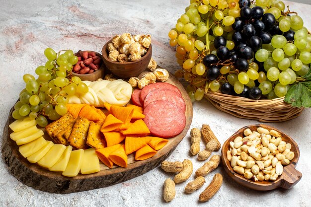 Vista frontale diversi snack uva fresca formaggio cips con noci su uno spazio bianco