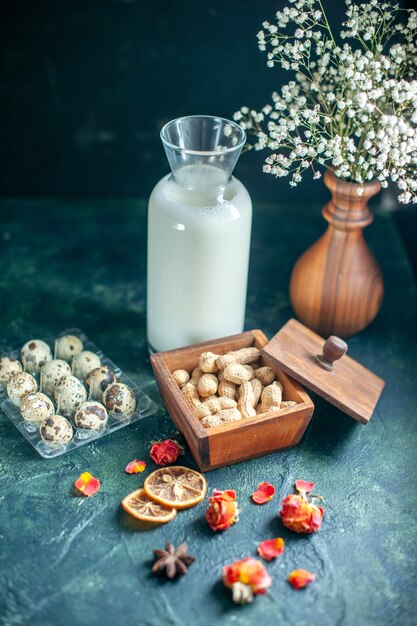 Vista frontale dolci deliziosi biscotti con latte e noci sulla superficie blu scuro