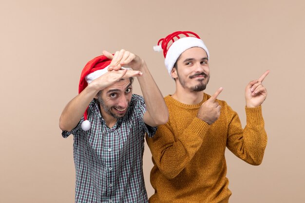 Vista frontale due uomini sorridenti con cappelli di Babbo Natale su sfondo isolato