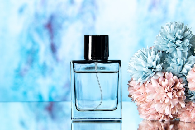 Vista frontale elegante profumo di fiori colorati su sfondo blu sfocato