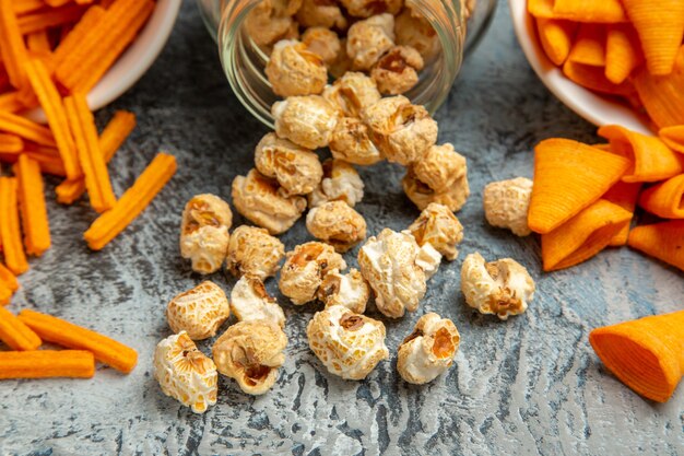 Vista frontale fette biscottate al formaggio con cips e popcorn su sfondo chiaro