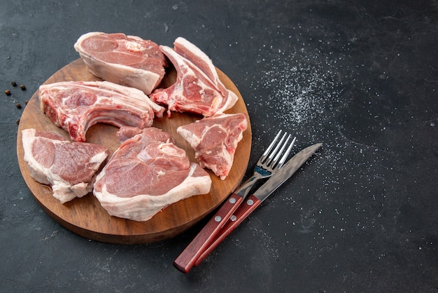 Vista frontale fette di carne fresca carne cruda su sfondo scuro barbecue cucina pasto cibo mucca cibo piatto insalata animale