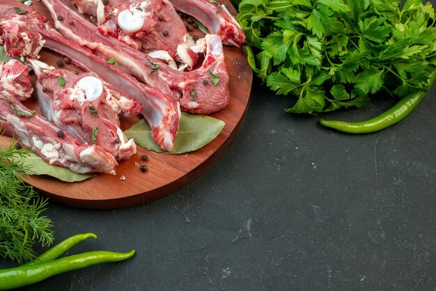 Vista frontale fette di carne fresca con verdure su sfondo scuro macellaio carne pollo pasto piatto cibo crudo cena
