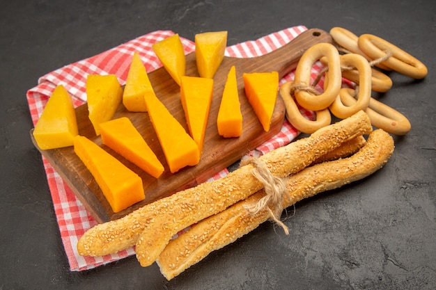 Vista frontale formaggio fresco a fette con focacce e cracker su pasto di colore grigio scuro foto colazione cips cibo