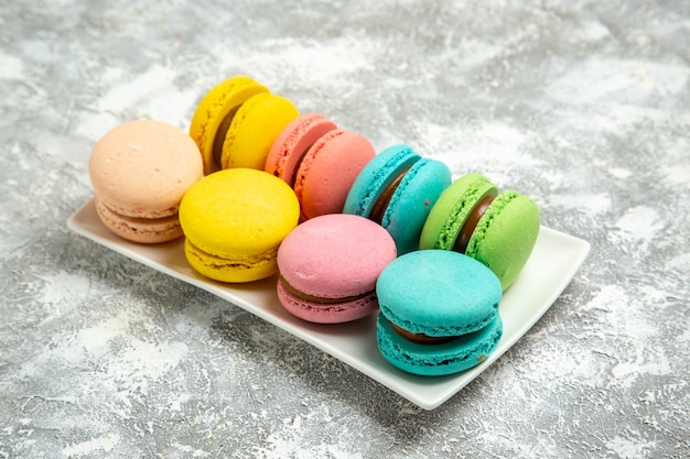 Vista frontale francese macarons torte colorate su superficie bianca torta torta zucchero cuocere biscotti dolci biscotti