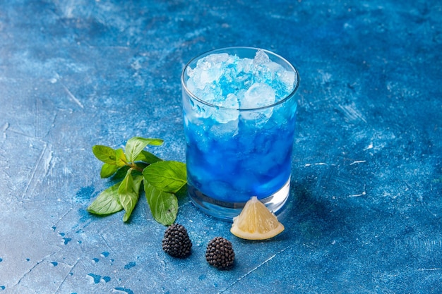 Vista frontale fresca fresca limonata all'interno di un piccolo bicchiere con ghiaccio su sfondo blu acqua fredda bevanda succo di frutta cocktail colori