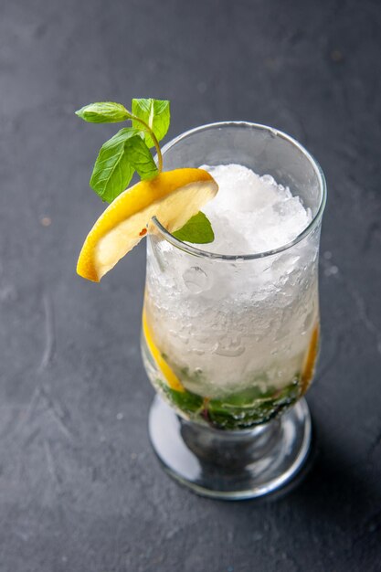 Vista frontale fresca fresca limonata con ghiaccio e limone su sfondo grigio frutta acqua cocktail drink color bar succo freddo