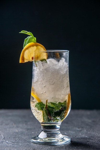 Vista frontale fresca fresca limonata con ghiaccio e limone su sfondo scuro frutta acqua cocktail drink color bar succo freddo