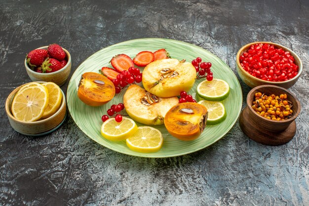 Vista frontale frutta fresca mele cotogne limoni e altri frutti sul tavolo leggero frutta fresca molti