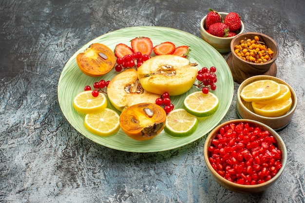 Vista frontale frutta fresca mele cotogne limoni e altri frutti sul tavolo luminoso