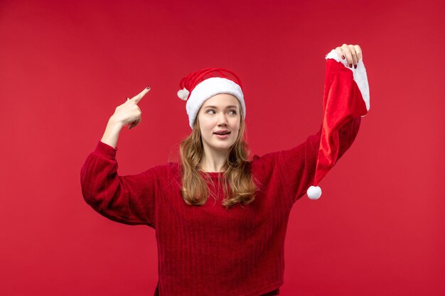 Vista frontale giovane donna con berretto rosso, vacanze natalizie