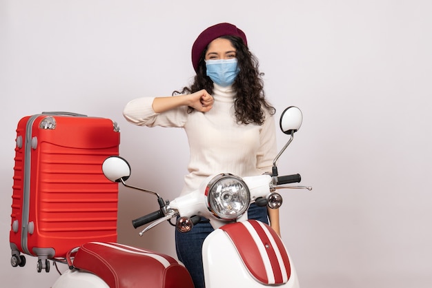 Vista frontale giovane donna con bici in maschera su sfondo bianco colore virus velocità covid- motocicletta veicolo pandemico