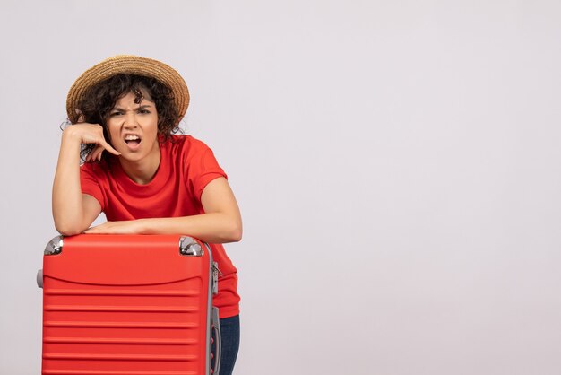 Vista frontale giovane donna con borsa rossa che si prepara per il viaggio su sfondo bianco aereo resto vacanza sole viaggio turistico volo