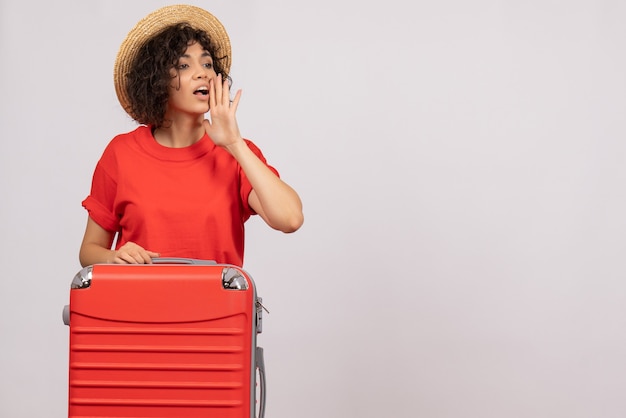 Vista frontale giovane donna con borsa rossa che si prepara per il viaggio su sfondo bianco volo colore aereo resto sole viaggio turistico vacanza