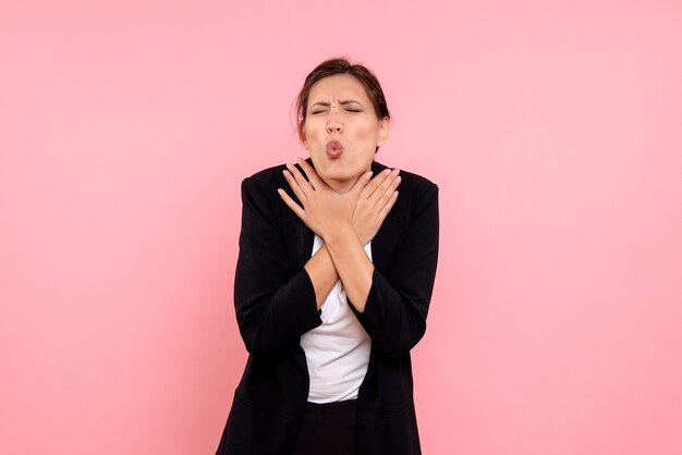 Vista frontale giovane donna graziosa in giacca scura su sfondo rosa