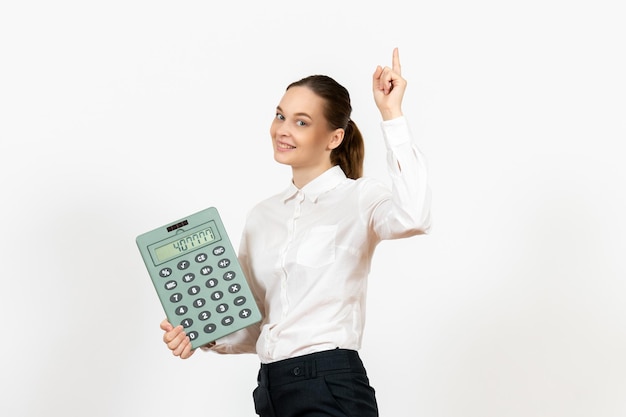 Vista frontale giovane donna in camicetta bianca che tiene grande calcolatrice su sfondo bianco ufficio emozioni femminili sentimenti lavoro lavoratore bianco