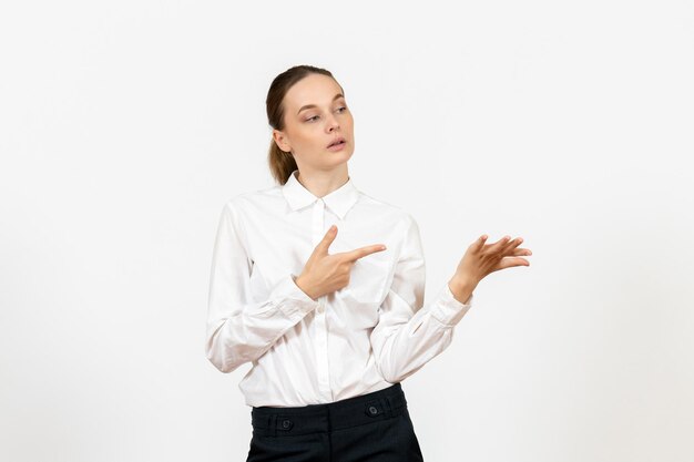 Vista frontale giovane donna in camicetta bianca con espressione annoiata su sfondo bianco lavoro ufficio femminile sentimento modello emozioni