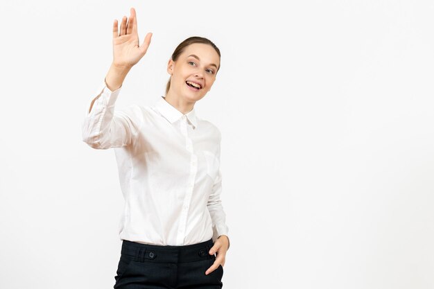 Vista frontale giovane donna in camicetta bianca con espressione eccitata su sfondo bianco modello femminile ufficio emozione lavoro sentimento