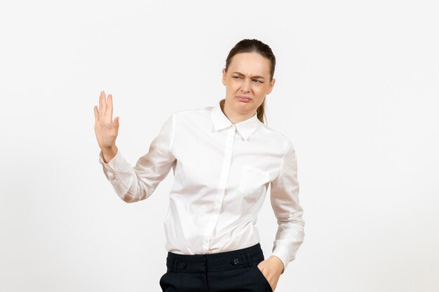 Vista frontale giovane donna in camicetta bianca con faccia confusa su sfondo bianco lavoro ufficio emozione femminile modello di sentimento