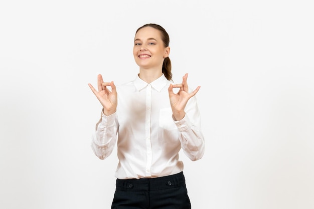 Vista frontale giovane donna in camicetta bianca con la faccia sorridente sullo sfondo bianco lavoro ufficio emozione femminile modello di sentimento