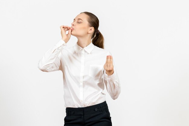 Vista frontale giovane donna in camicetta bianca con viso felice su sfondo bianco lavoro sentimento femminile modello emozione ufficio