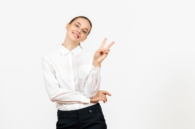 Vista frontale giovane donna in camicetta bianca con volto sorridente su sfondo bianco lavoro d'ufficio emozioni femminili sentimento modello feeling