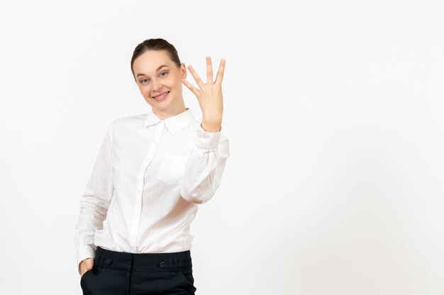 Vista frontale giovane donna in camicetta bianca con volto sorridente su sfondo bianco lavoro ufficio sentimenti femminili modello emozione