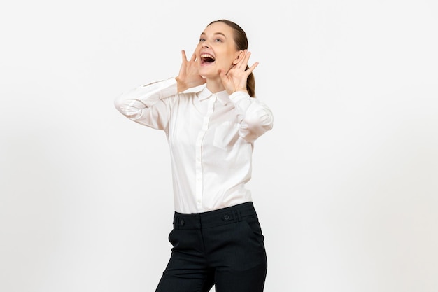 Vista frontale giovane donna in elegante camicetta bianca che ride su sfondo bianco donna lavoro d'ufficio signora lavoratrice