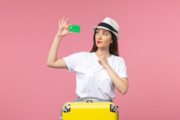 Vista frontale giovane donna in possesso di carta di credito sul muro rosa emozione viaggio estivo donna