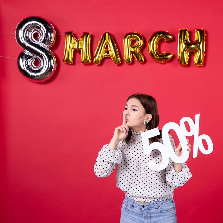 Foto gratuito vista frontale giovane femmina che tiene la scrittura su marzo decorato sfondo rosso shopping bellezza vacanza uguaglianza moda donna centro commerciale