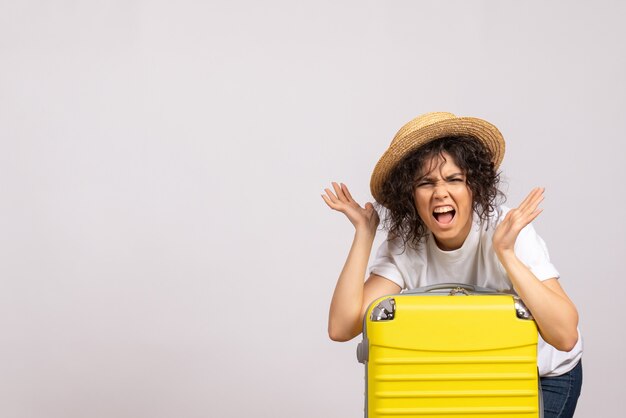 Vista frontale giovane femmina con borsa gialla che si prepara per il viaggio su sfondo bianco sole colore viaggio vacanza aereo resto volo turistico