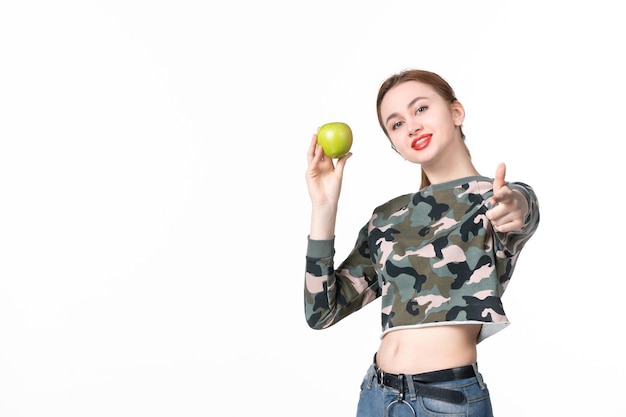 Vista frontale giovane femmina con mela verde su sfondo bianco succo di pelle di frutta orizzontale dieta umana assistenza sanitaria