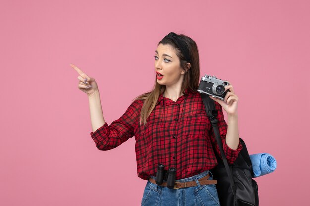 Vista frontale giovane femmina di scattare una foto con la fotocamera su sfondo rosa chiaro modello di foto della donna